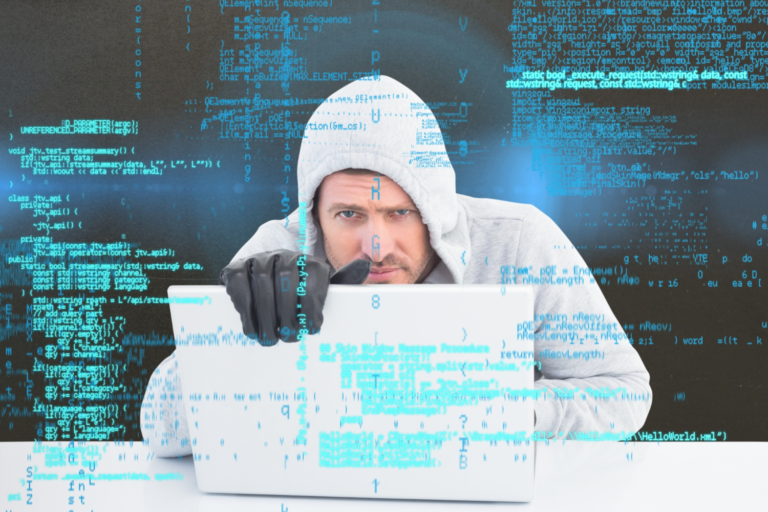 Un hombre con capucha y una computadora portátil